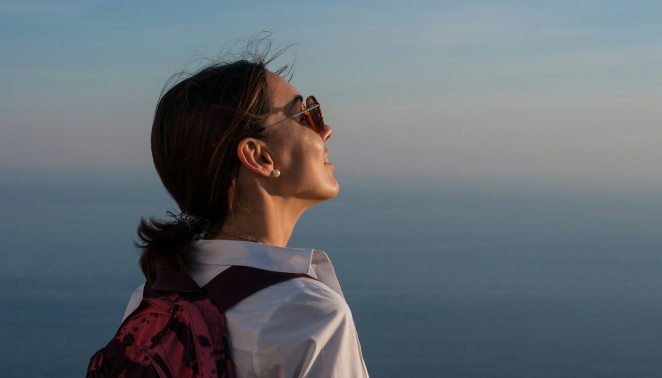 travel, itinerary, woman with a backpack looking at the sky