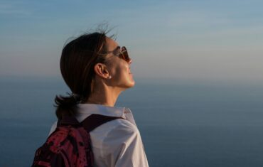 travel, itinerary, woman with a backpack looking at the sky